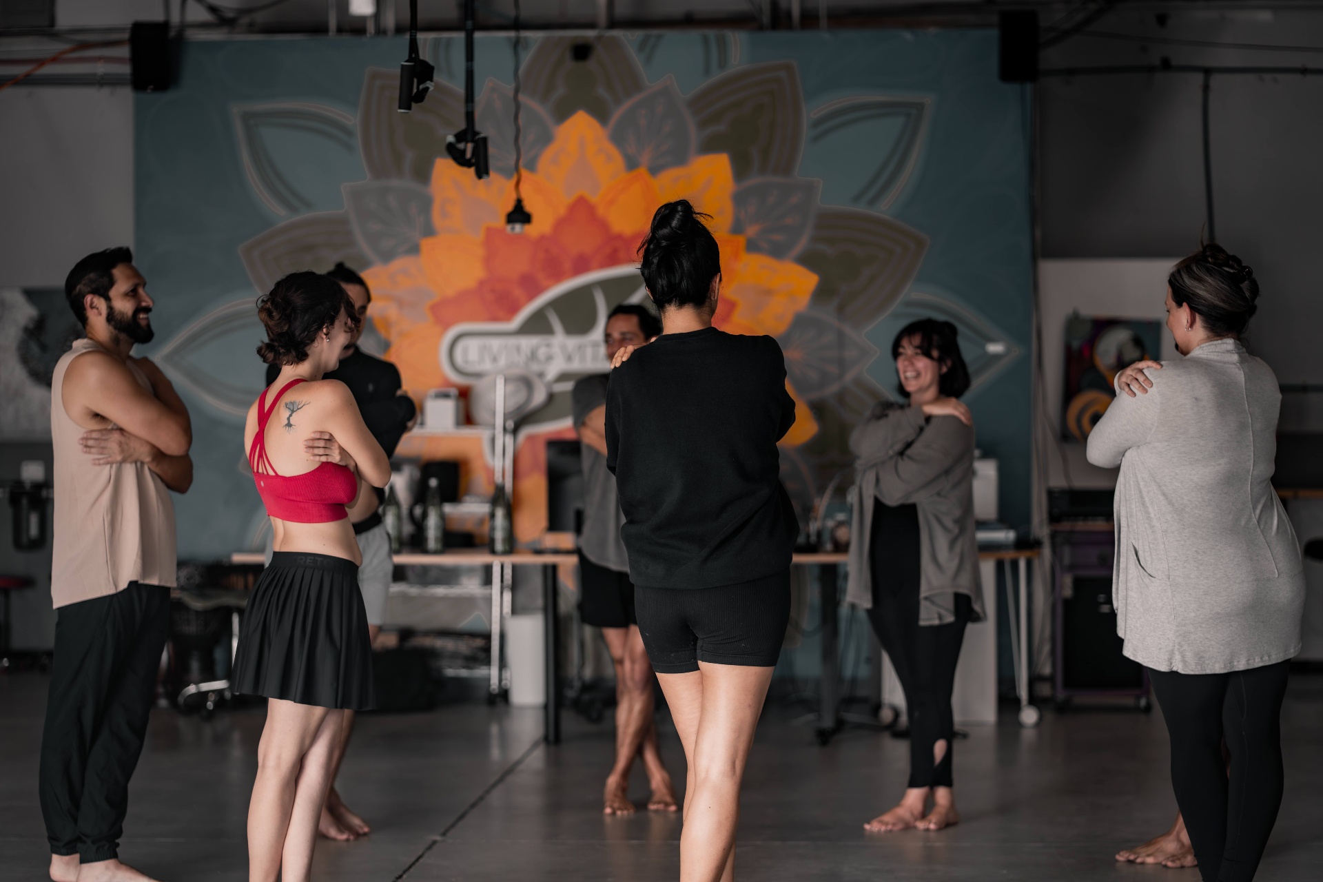 A circle of participants laughing together during a group practice