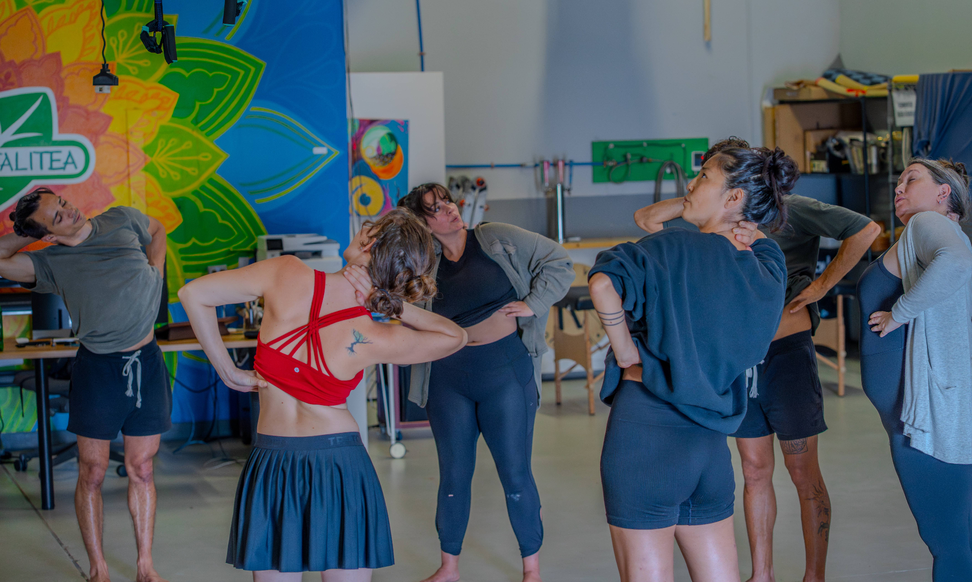 A group of practitioners moving together through a side-stretch sequence