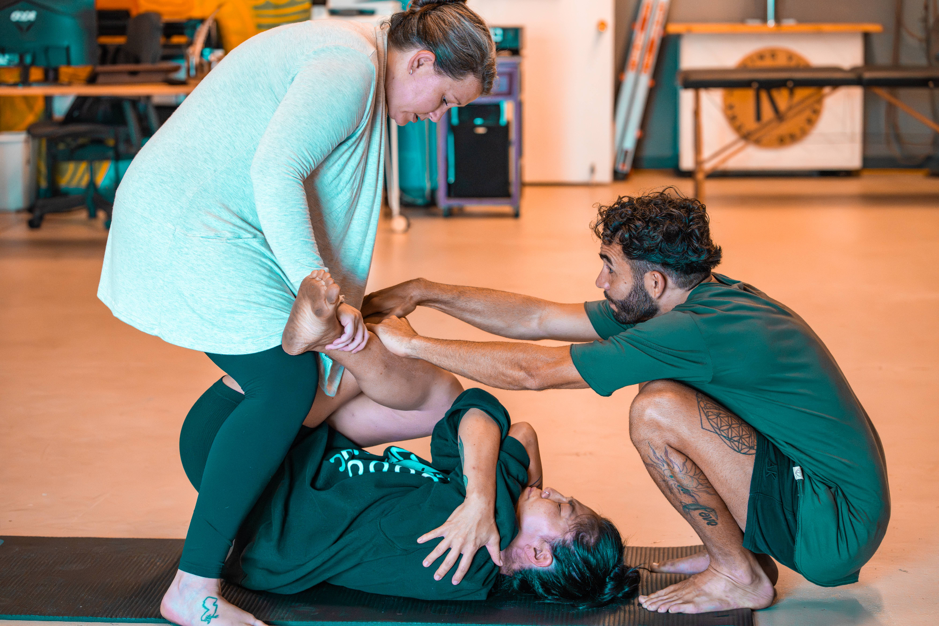 Two guides offering hands-on support to a participant on the floor