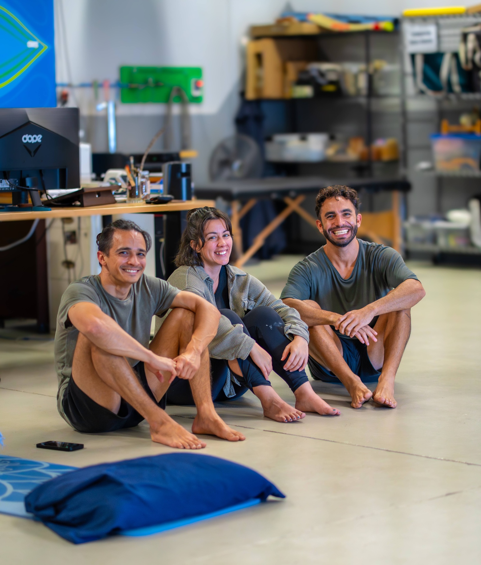Wolf, Christi, and Anthony sitting together on the floor, laughing